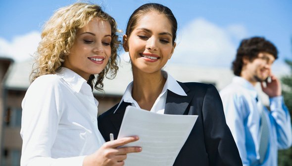 Two women reviewing a residential rental application happily
